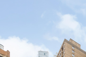 a large white building in a city with tall skyscrapers